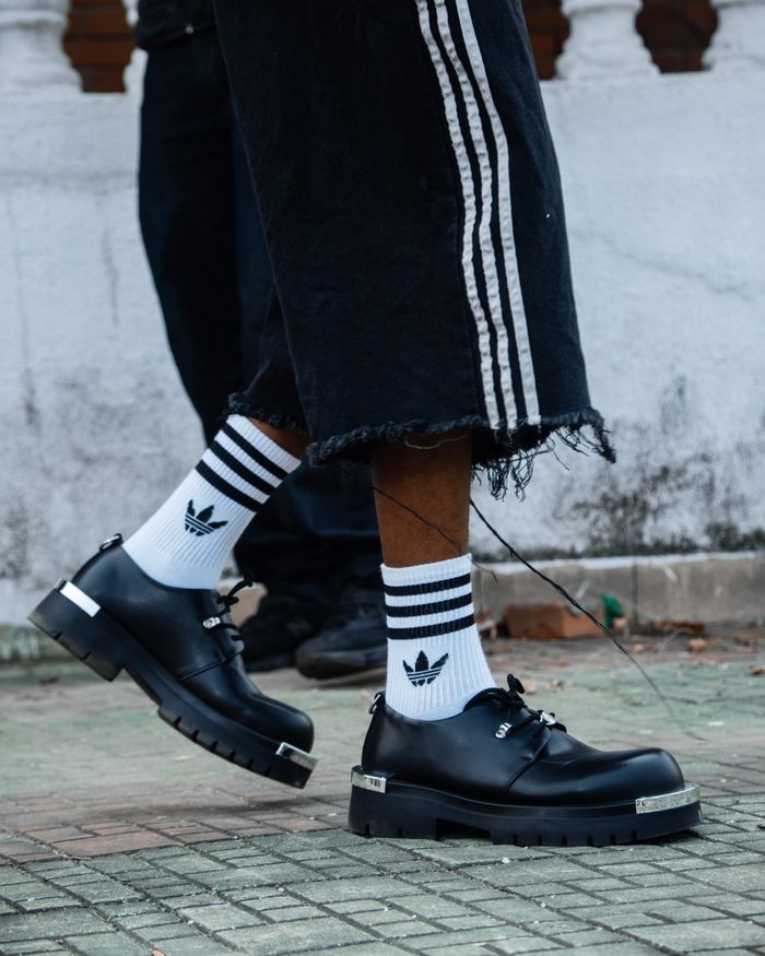 Close-up of trendy streetwear style featuring sneakers and striped socks, ideal for fashion inspiration.