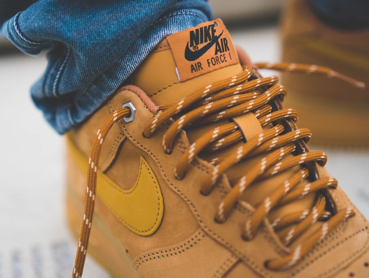 Detailed shot of brown Nike Air Force 1 sneakers with laced design and subtle branding.